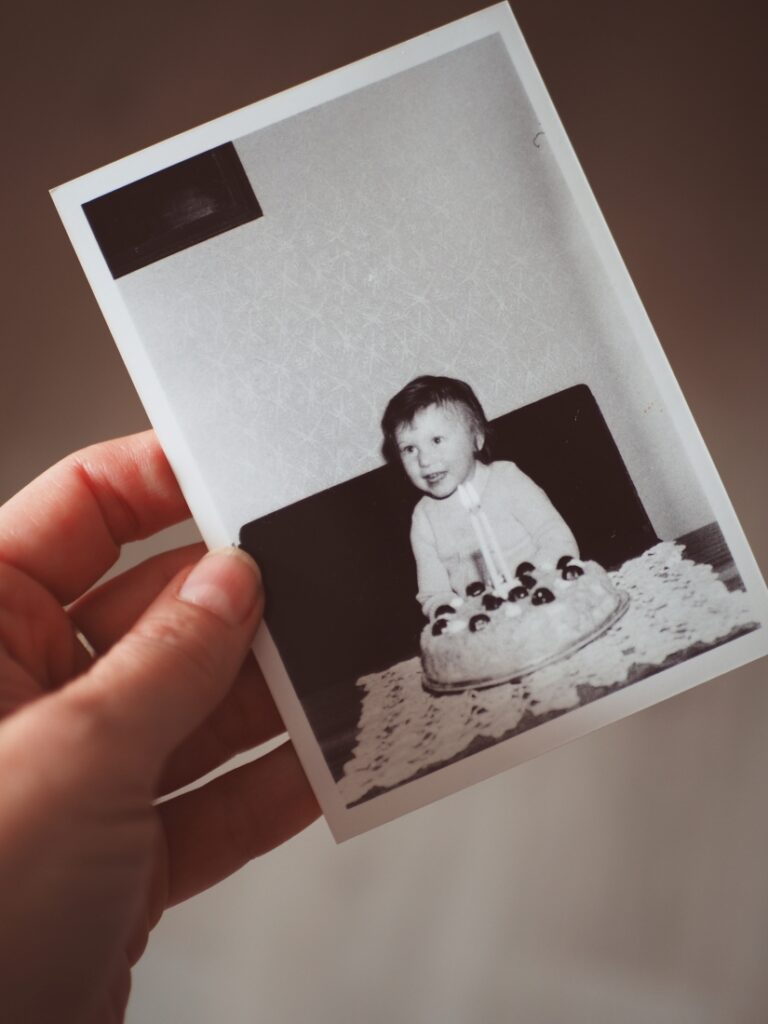 Stará rodinná fotografie malé holčičky s&nbsp;narozeninovým dortem