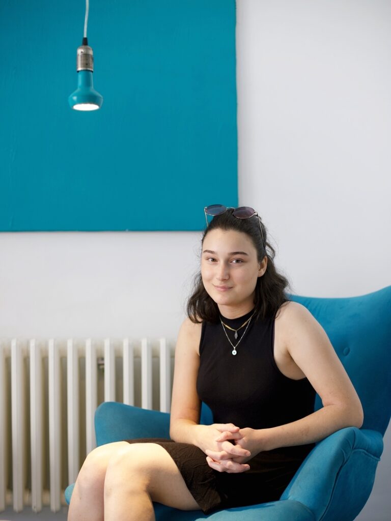Žena sedící v modrém křesle během osobního portrétního focení.