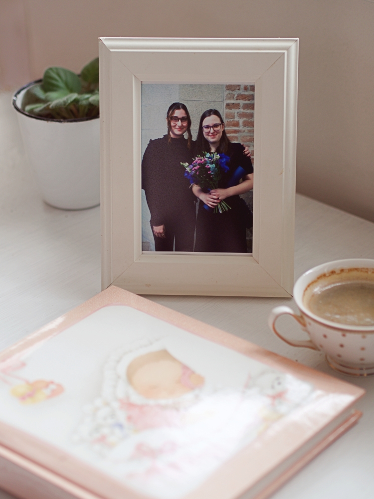 zátiší s fotografií dcer v rámečku a dětské fotoalbum